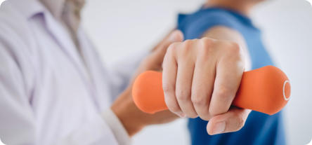A patient lifting a small weight while a doctor guides their arm as part of a physical therapy routine.