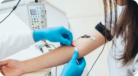 A medical professional in scrubs using a medical device to diagnose a patient's wrist